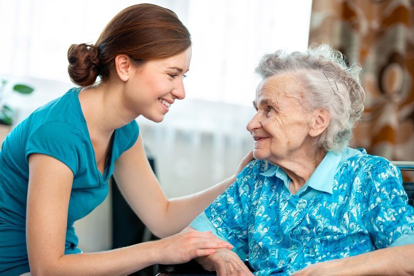 caregiver smiling with a senior lady