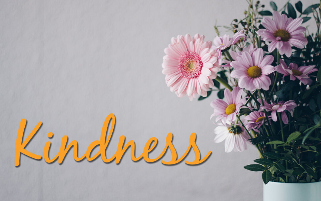 Vase full of flowers with the bold word "Kindness" in the center of the image