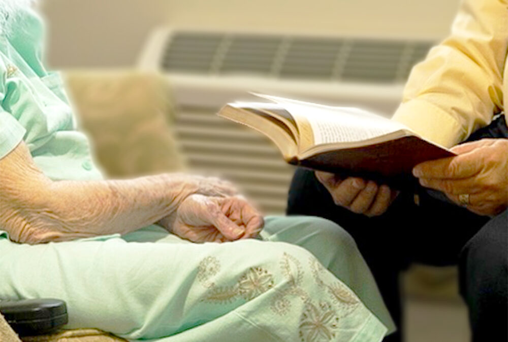 Elderly woman studying scripture with caregiver